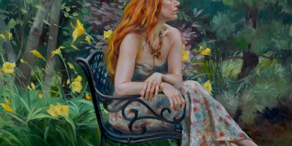 Young woman with red hair in a floral dress sitting on a wrought iron chair in a garden blooming with yellow lilies