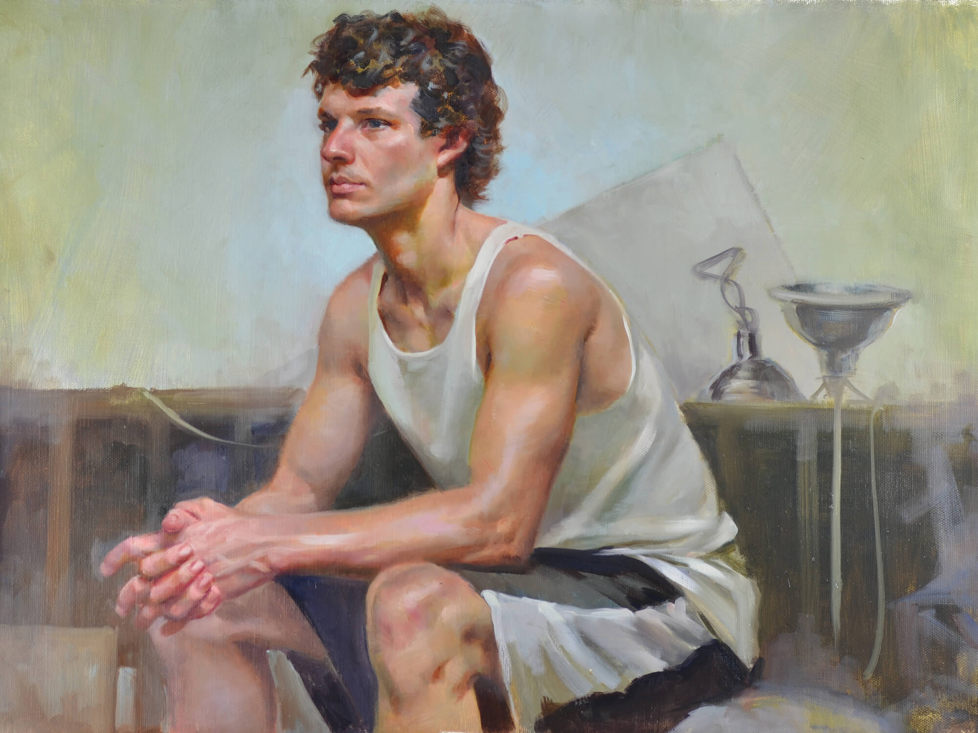 Figurative oil portrait of a young man wearing a muscle t-shirt and shorts sitting with his hands clasped and clamp lights behind him