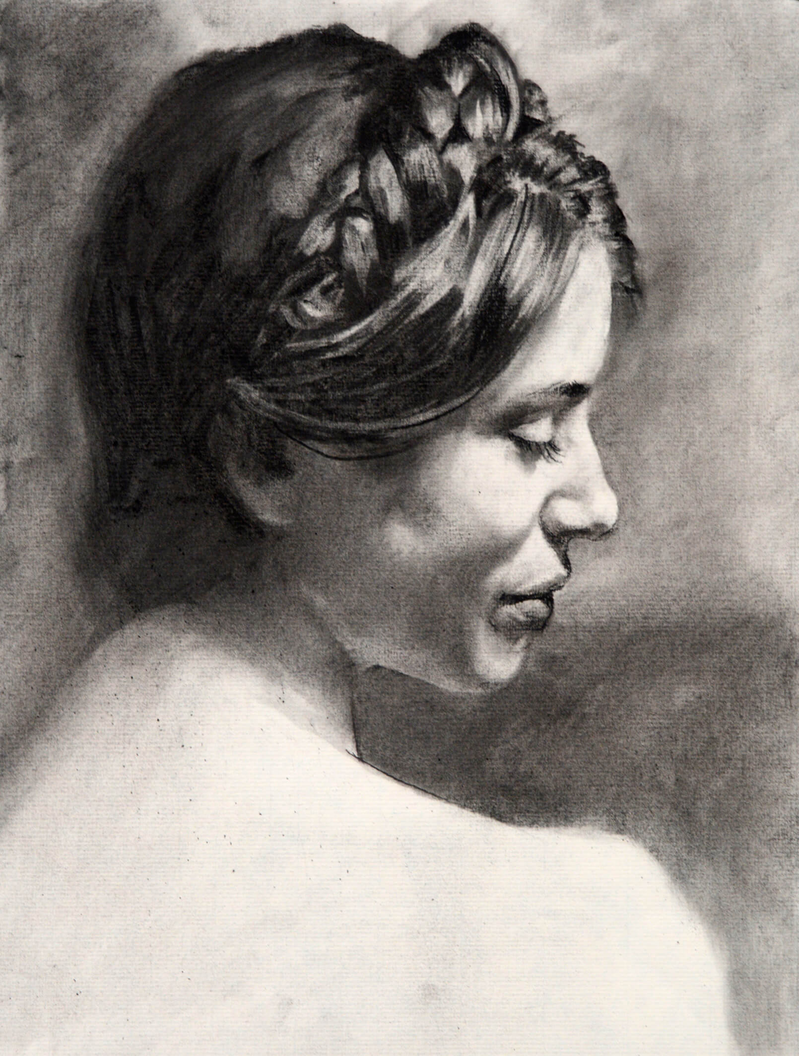 Realistic charcoal portrait of a woman with a top braid in profile with a downward gaze