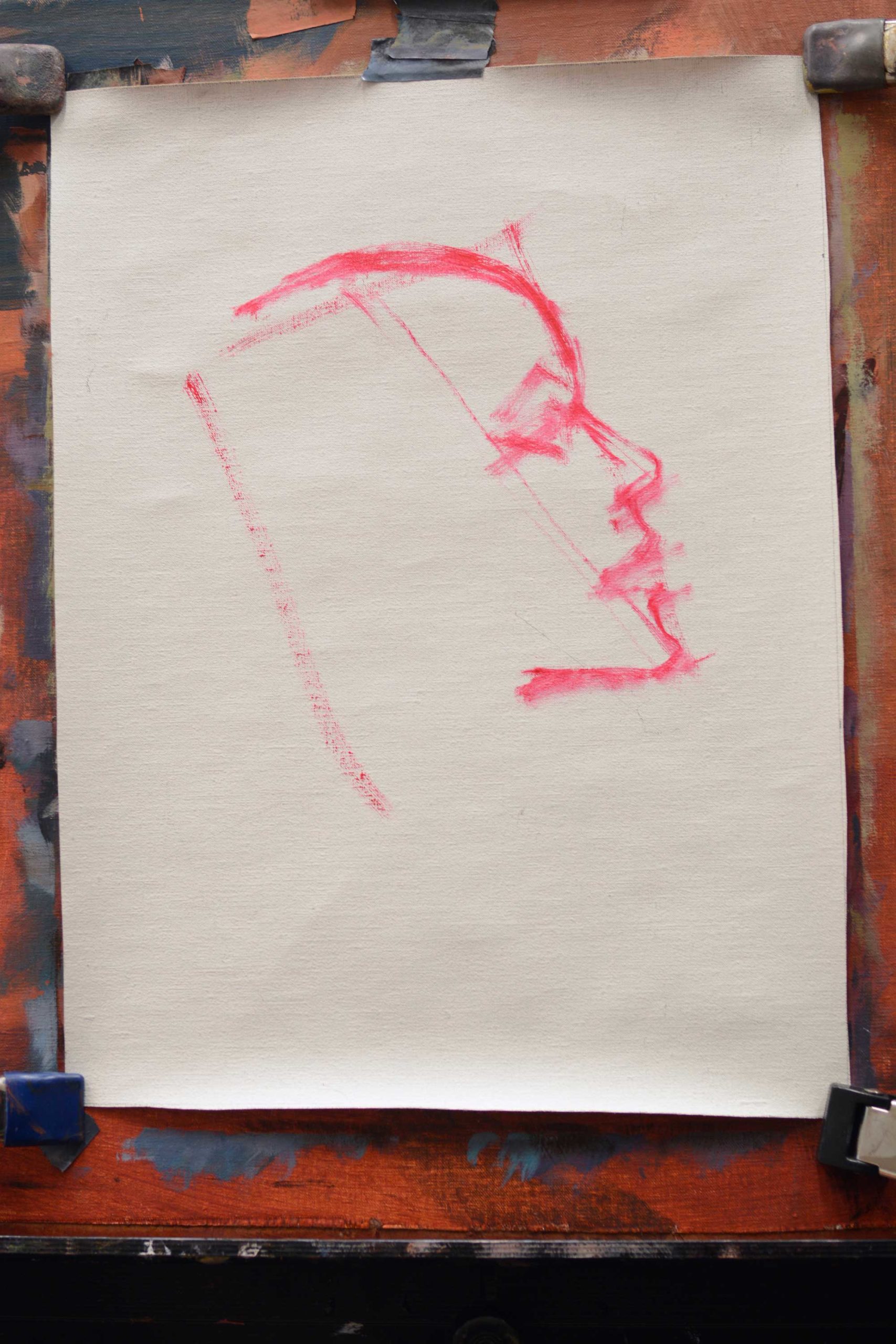 Artist canvas with rough sketch in a bright paint of a head in profile