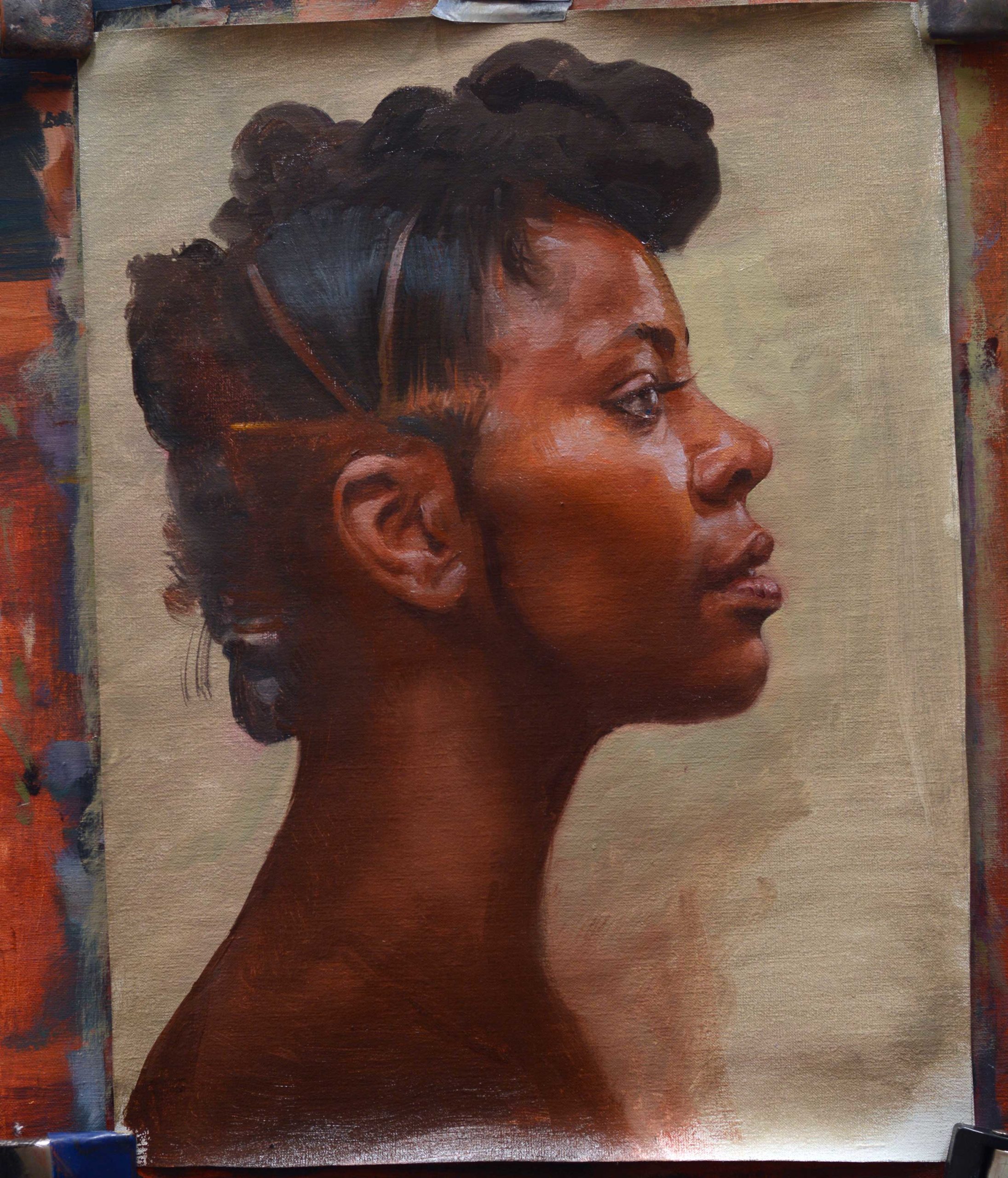 Making small adjustments in an oil painted portrait of a head in profile